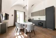 115,42 m² Design-Altbau mit Gewölben & Eigengarten-Terrasse sowie Poolnutzung – elegante Wohnküche, XL-Regendusche